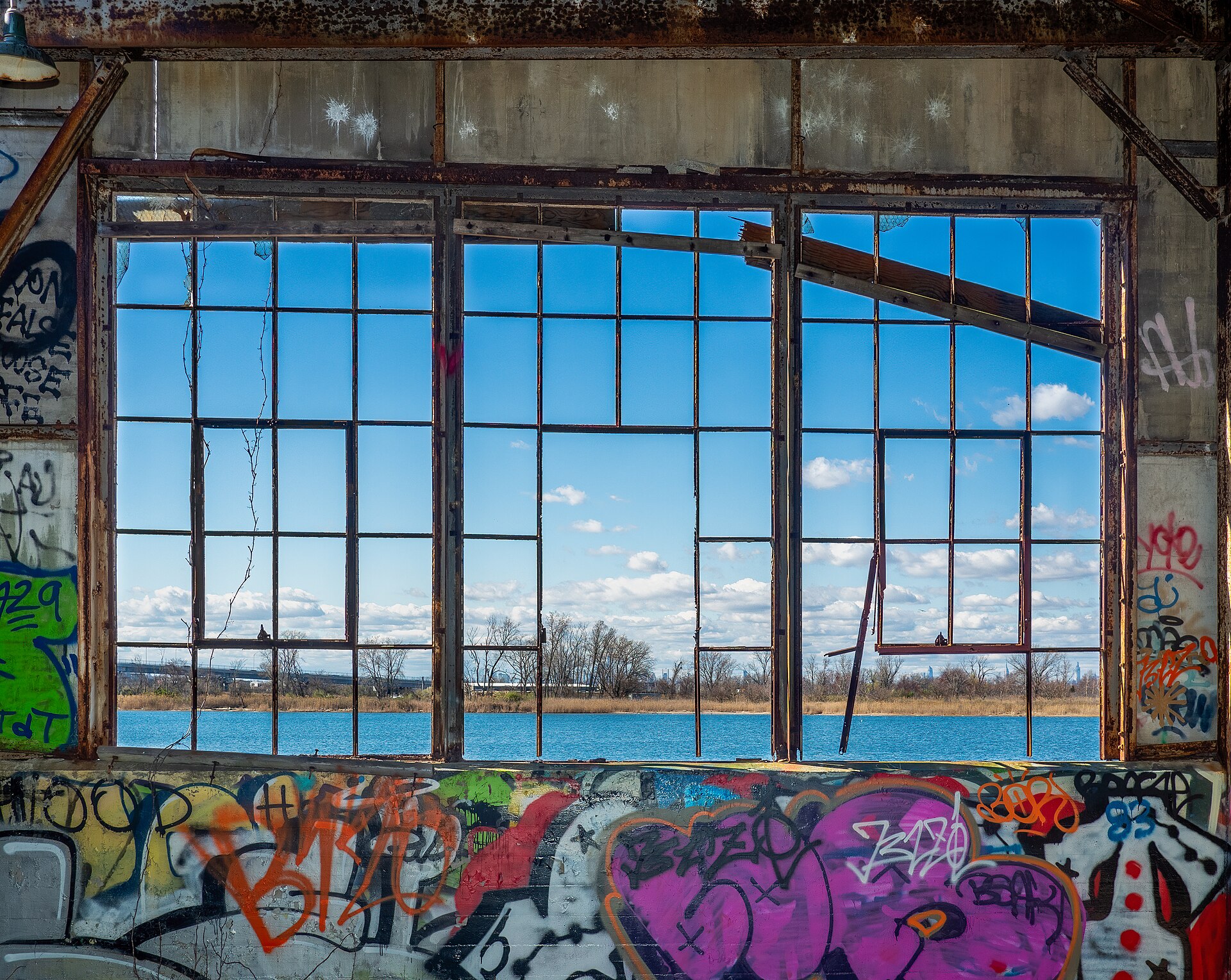 An abandoned building with a window frame overlooking water, representing the theme of finding hope amidst decay.