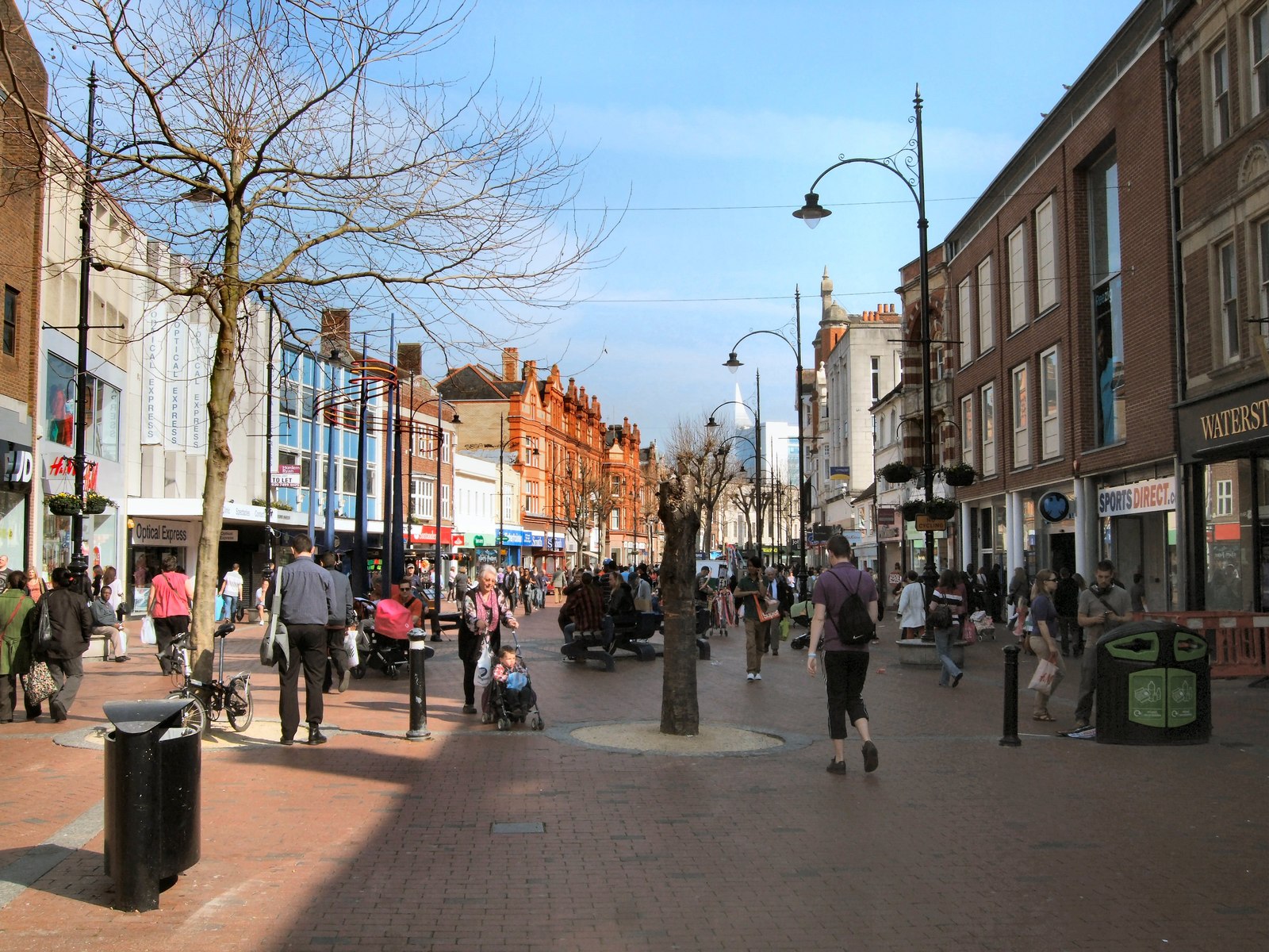 A busy pedestrian street scene with shops and people walking, reflecting the vibrant energy of desi fashion.